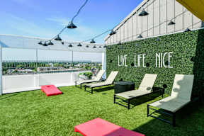 A patio with chairs and a wall that says