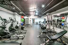 A gym with a row of treadmills and elliptical machines.