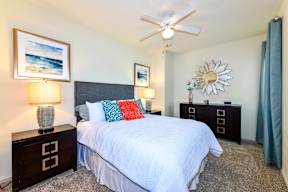 A bedroom with a bed, nightstands, and a ceiling fan. at Park at Forest Hill Apartments, Memphis, Tennessee