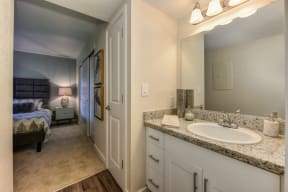 Bathroom with Adjoining Bedroom, White Cabinets and Vanity