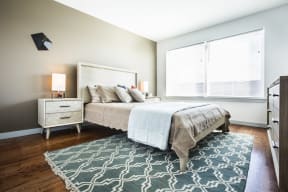 Model bedroom with hardwood floors and large windows