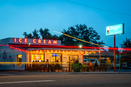 a nighttime view of an ice cream restaurant with a neon sign that reads ice cream