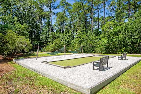 A backyard with a swing set and a sandbox.