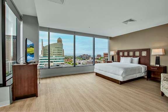 A bedroom with a large bed and a view of the city.