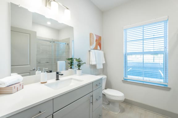 a white bathroom with a large mirror and a toilet