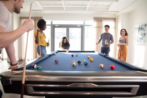 a group of people playing a game of pool at Versus, Calgary, Alberta, T2R 1A8