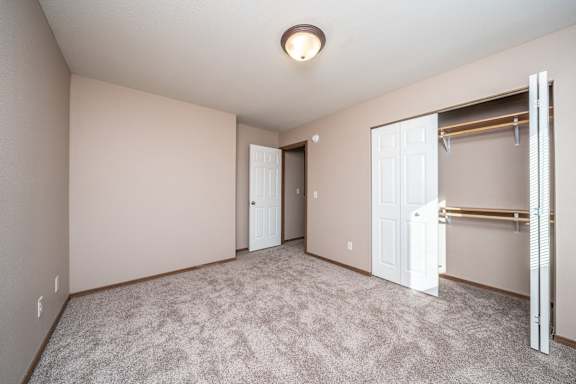 A room with a carpeted floor and a white door.