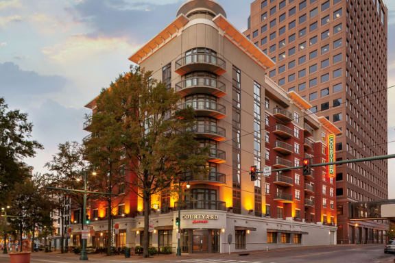 a hotel building on the corner of a city street at sunset