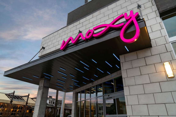 the facade of a macys store with a pink neon sign