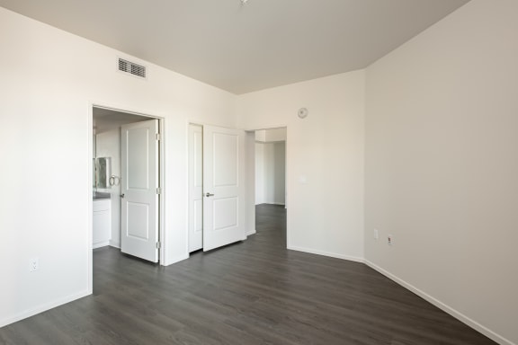 an empty living room with white walls and wood floors