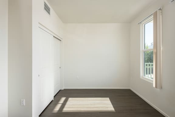 an empty room with white walls and a window