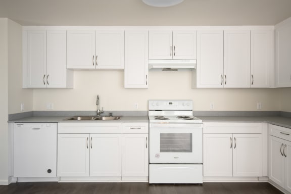 a kitchen with white cabinets and a stove and a sink