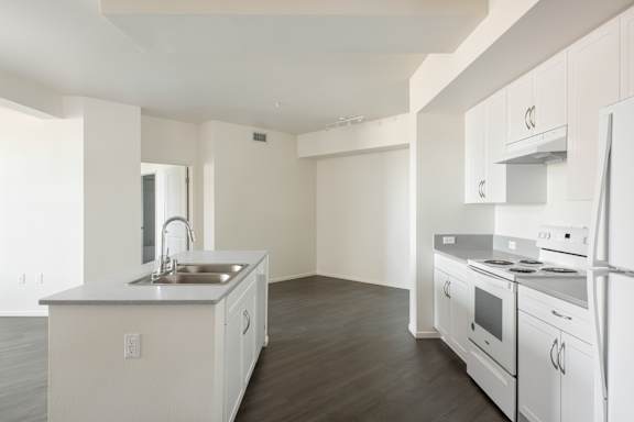 a kitchen with white cabinets and white appliances and a sink