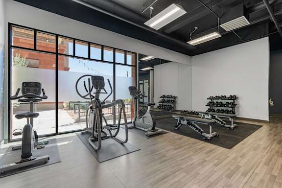 a gym with weights and other exercise equipment and a large window at City View St. George, St. George, Utah