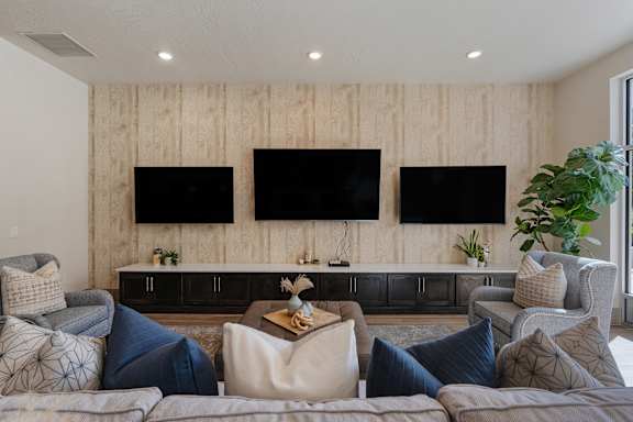 Living room with couches and chairs and televisions on the wall at 200 City View, Provo