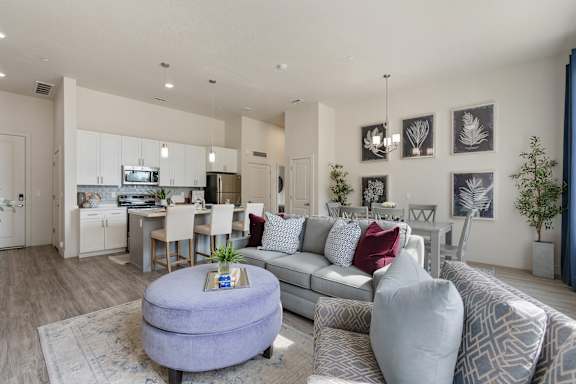 Modern living room with a grey couch and a round ottoman at 200 City View, Provo, Utah