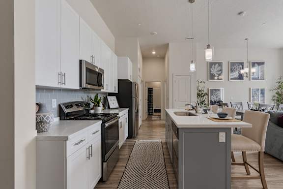 A modern kitchen with white cabinets and a large island.