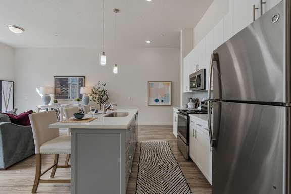 Modern kitchen with a stainless steel refrigerator and a dining table with chairs at 200 City View, Provo, 84601