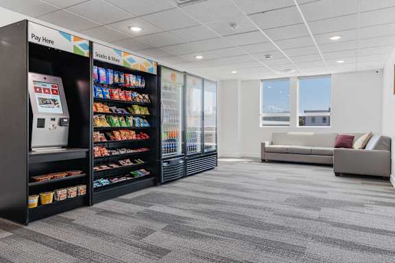 A vending machine is located in a room with a couch and a window. 605 Place Student Housing & Co-Living, St George, 84770