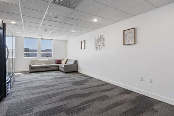 A room with a grey carpet and a white wall with two pictures on it. 605 Place Student Housing & Co-Living, St George, UT