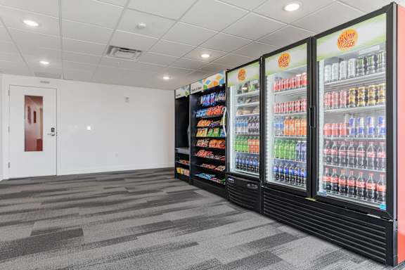 A room with a wall of drinks and a door on the left. 605 Place Student Housing & Co-Living, Utah