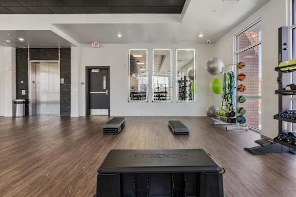A gym with a wooden floor and a variety of equipment 605 Place Student Housing & Co-Living, St George, UT 84770.