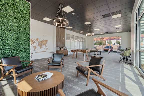 large lobby with black chairs and tables and a green wall 605 Place Student Housing & Co-Living, St George Utah