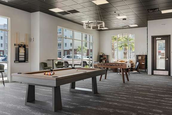 A billiard table is in the middle of a room with a black ceiling and floor. 605 Place Student Housing & Co-Living, St George, UT