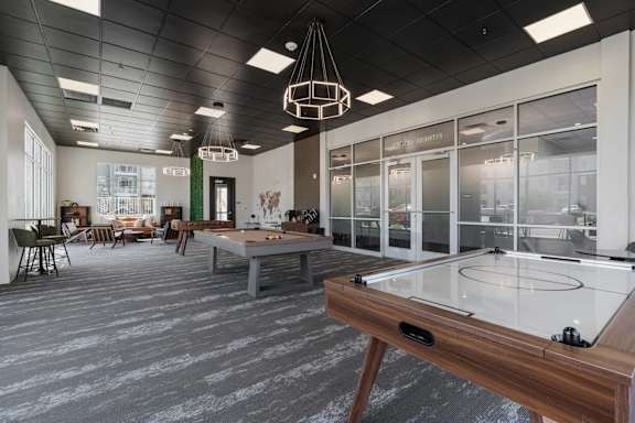 A foosball table is in the middle of a room with a ping pong table in the foreground. 605 Place Student Housing & Co-Living, Utah