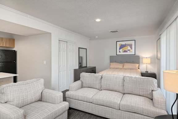A living room with a grey couch and a white chair.