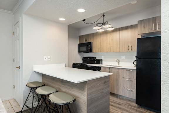A kitchen with a white countertop and black appliances.