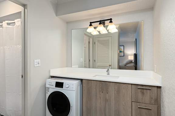 A bathroom with a washer and dryer built into the cabinetry.