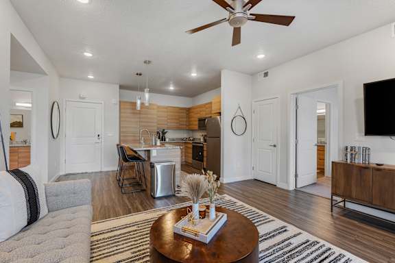A modern living room with a wooden coffee table in the center.