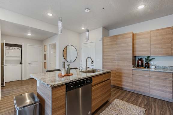 A modern kitchen with wooden cabinets and a marble countertop.