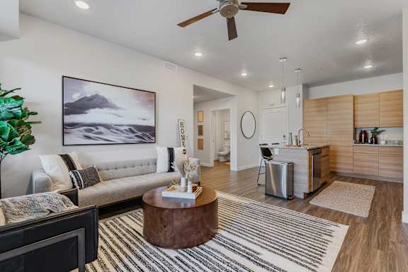 A living room with a grey couch and a brown coffee table.