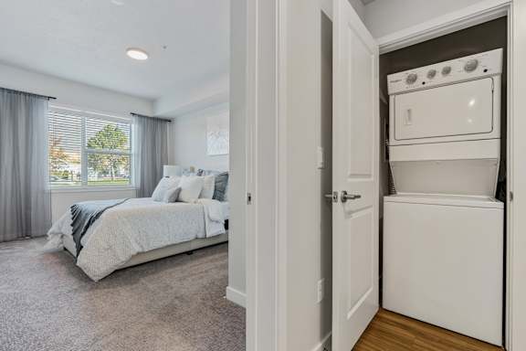 A bedroom with a large bed and a small kitchenette.