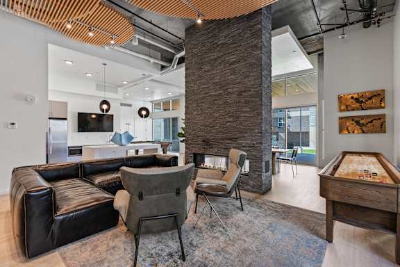 A modern living room with a black leather couch and a wooden coffee table.