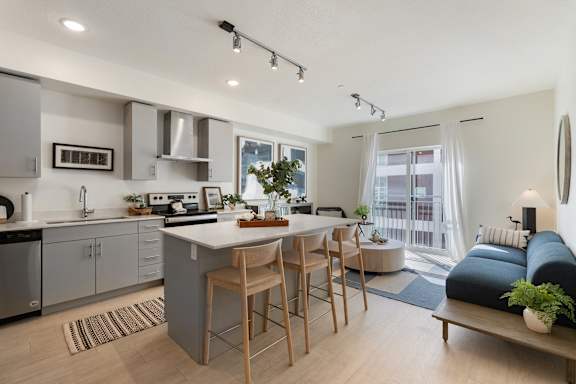 A modern kitchen with a dining area and a living room.