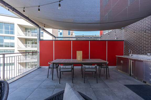 A patio with a table and chairs under a white canopy.