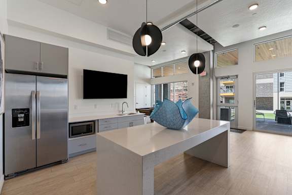 A modern kitchen with a large island and stainless steel appliances.