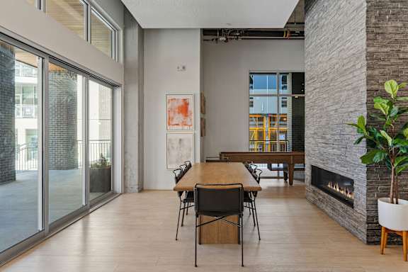 A room with a table and chairs and a fireplace.