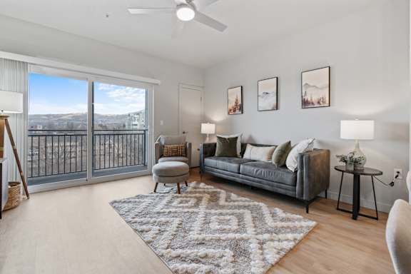A living room with a grey couch, a rug, and pictures on the wall.