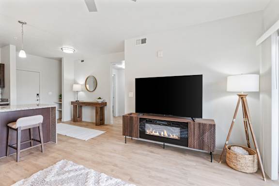 A modern living room with a flat screen TV and a fireplace.