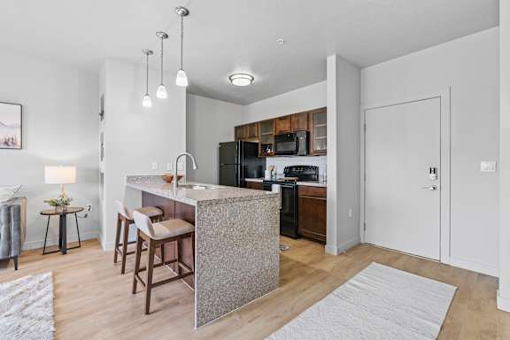 A kitchen with a bar stool and a counter.