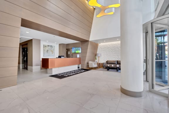 the lobby of a hotel with a reception desk and a yellow light fixture