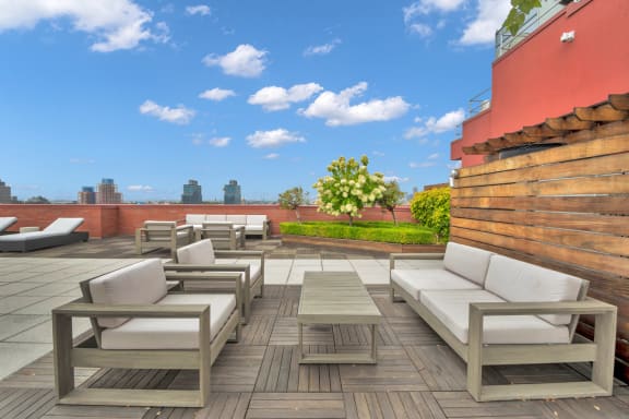 a terrace with white couches and tables on a rooftop