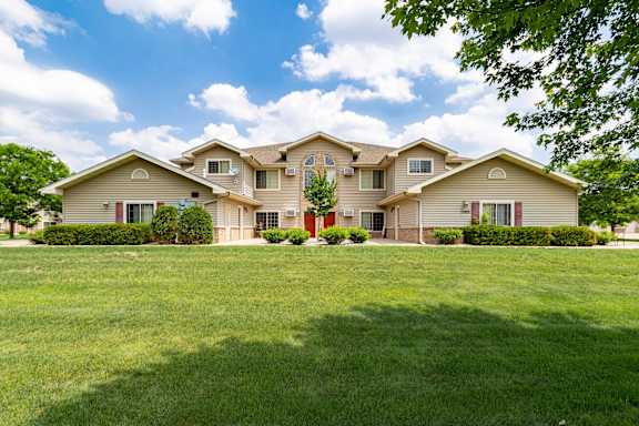A large house with a green lawn in front.