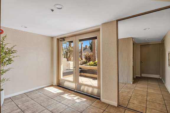 A room with a sliding glass door leading to a balcony.