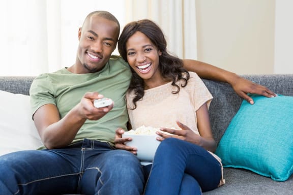 a man and woman sitting on a couch playing with a remote control at Capitol Crossing, Austin, TX 78744