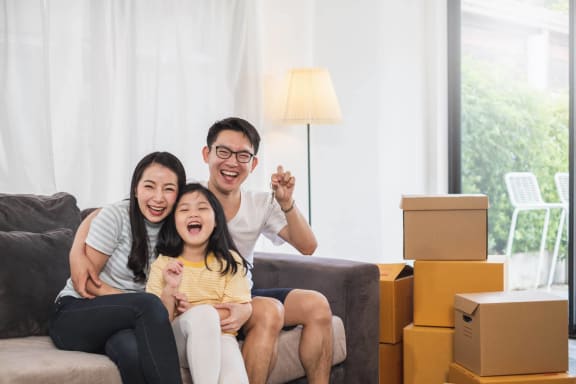 a family sitting on a couch in a living room looking at a tablet at Millberry Apartments, St. Paul, MN